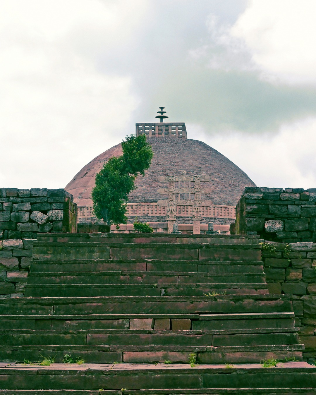 On a hill in Madhya Pradesh, Sanchi's Great Stupa and its intricately carved gateways represent Buddhist art from the 3rd century BCE onwards – among India's oldest stone sculptures, where narrative reliefs tell stories of Buddha's life and Jataka tales with extraordinary detail and artistic sophistication.
Emperor Ashoka commissioned the original stupa in the 3rd century BCE, though the magnificent gateways (toranas) were added later in the 1st century BCE. The stupa itself is simple – a massive hemispherical dome representing Buddha's presence, surrounded by a stone railing with four elaborately carved gateways facing cardinal directions.
These gateways hold Sanchi's artistic genius. Carved from sandstone, they're covered in relief sculptures depicting Buddha's previous lives, his path to enlightenment, and early Buddhist symbols. Interestingly, Buddha himself isn't shown in human form – early Buddhist art represented him through symbols: the Bodhi tree, footprints, an empty throne, or the dharma wheel. This symbolic representation rather than direct depiction creates narrative requiring viewers to interpret.
The carvings show remarkable detail – elephants, horses, humans in various activities, trees, architectural elements, all rendered with naturalism and artistic confidence. The yakshi (female figure) bracket figures supporting gateway architraves are particularly celebrated – sensuous, graceful sculptures that influenced Indian art for centuries.
Sanchi survived because it was abandoned and forgotten, rediscovered only in 1818. This isolation protected what war or religious change destroyed elsewhere – giving us one of the most complete early Buddhist artistic sites surviving anywhere.
Sanchi represents Indian sculpture at its beginning – the artistic vocabulary being established that would evolve for two millennia.
#EnrichingJourneys
#TravelWithEJ
#Sanchi #SanchiStupa #MadhyaPradesh #BuddhistArt #BuddhistSculpture #AncientIndia #SculpturalMasterpieces #AshokanEra #UNESCOWorldHeritage #India #IndiaTravel #TravelIndia #ExploreIndia #IncredibleIndia #BuddhistHeritage #IndianHeritage #CulturalHeritage #IndianArt #BuddhistMonuments